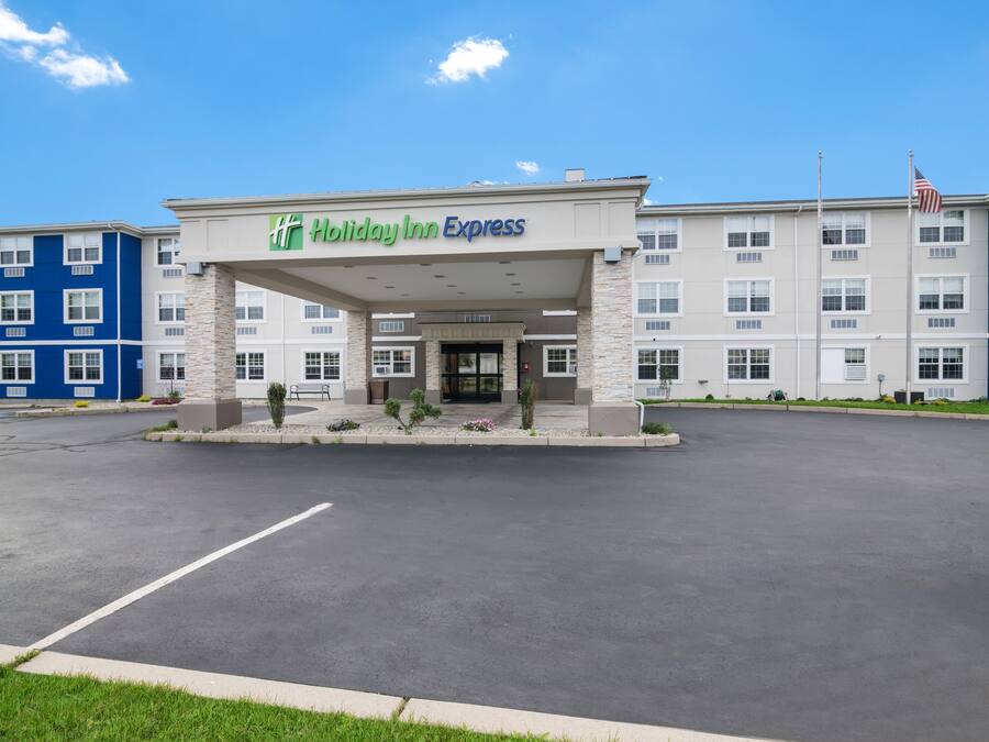 Edificio de Holiday Inn Express con entrada cubierta, varias ventanas y un estacionamiento.