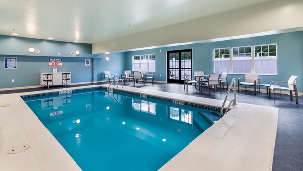 Une piscine avec des chaises longues et un panneau de sécurité.