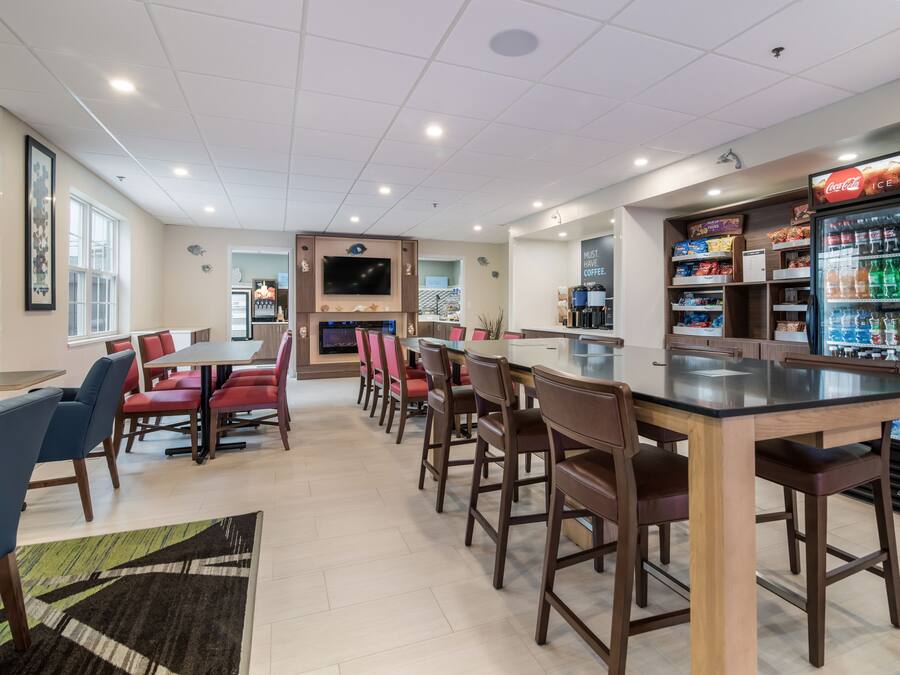A spacious restaurant with multiple dining areas, a bar, and a Coca-Cola refrigerator.