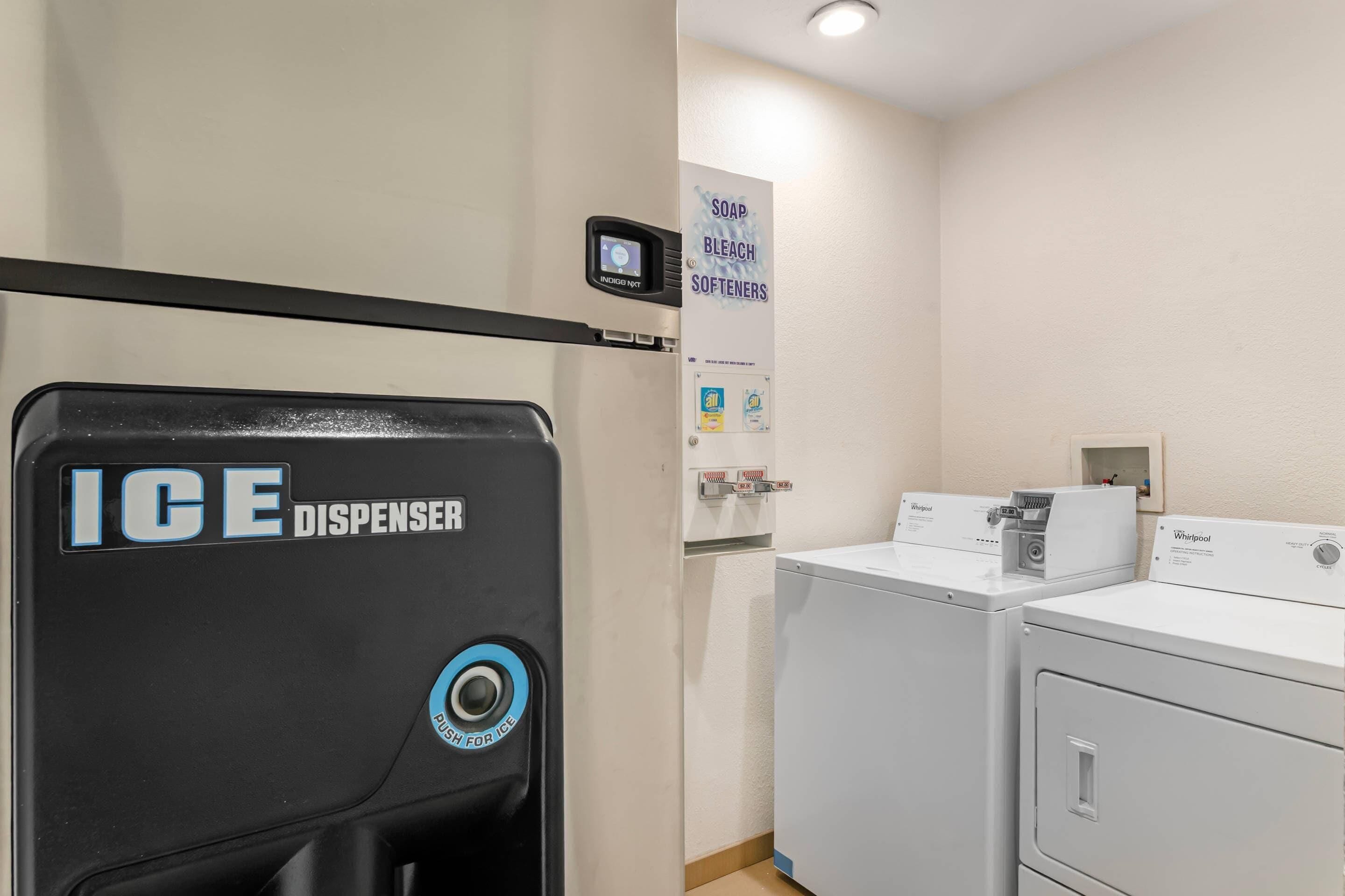 A laundry area with an ice dispenser, a washer, and a dryer.