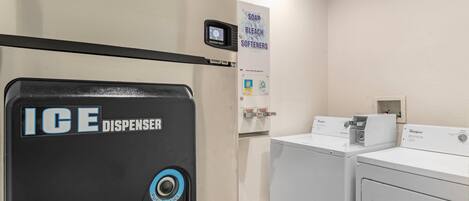 A laundry area with an ice dispenser, a washer, and a dryer.