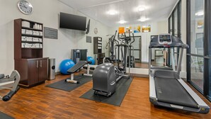 A gym with exercise equipment, a treadmill, and a mirrored wall. - Comfort Inn & Suites Kansas City - Northeast (Kansas City)