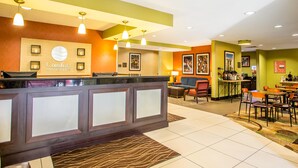 A hotel reception area with a modern design, featuring a reception desk, seating area, and a bar. - Comfort Inn & Suites Kansas City - Northeast (Kansas City)