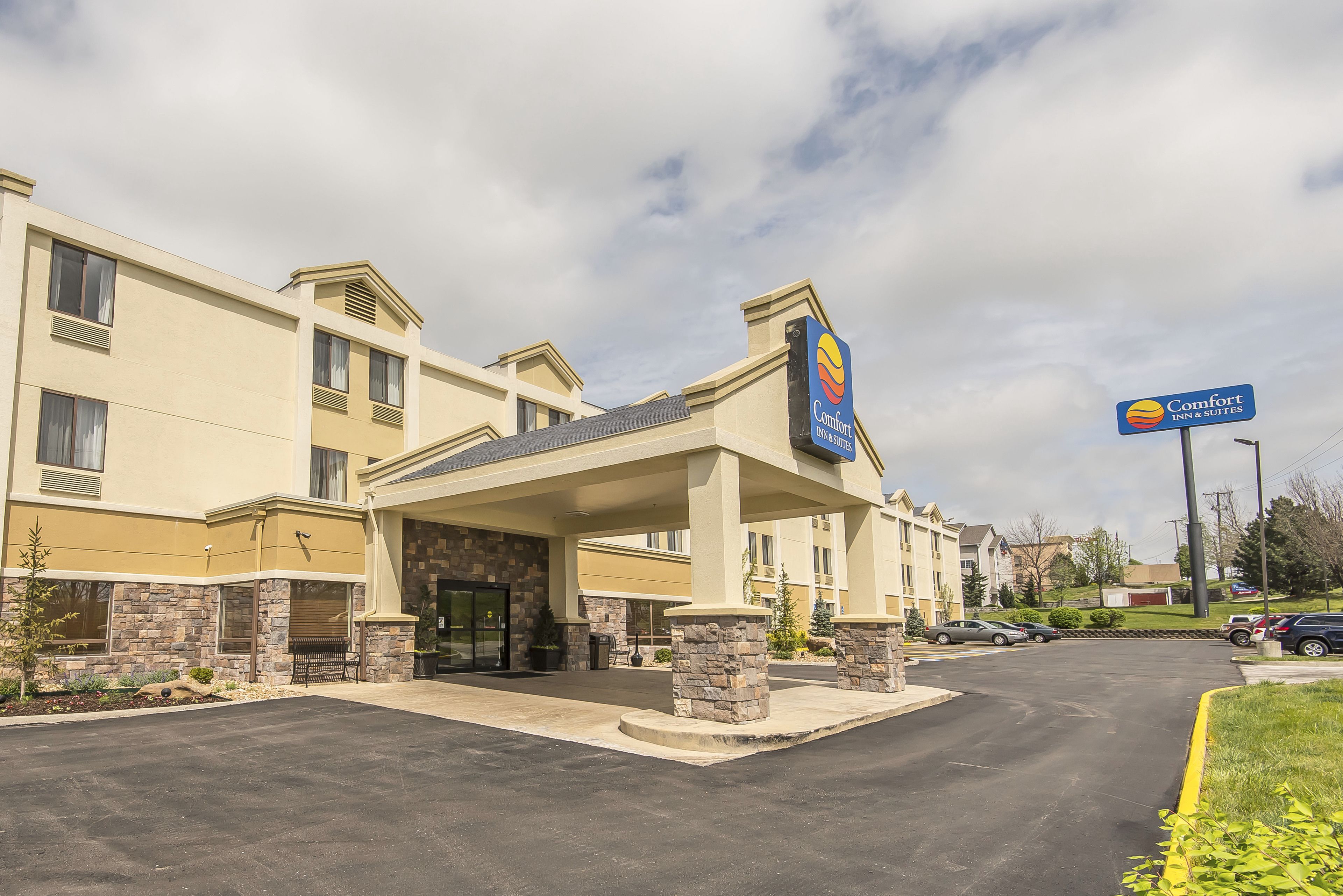 A Comfort Inn & Suites hotel with a stone facade, a covered entrance, and a parking lot.