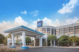 A Baymont Inn & Suites with a gas station in front.