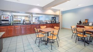 Una cocina moderna con una isla central, sillas de madera y una mesa de comedor.