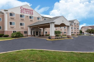 Um hotel Comfort Suites com entrada coberta, vários andares e estacionamento.