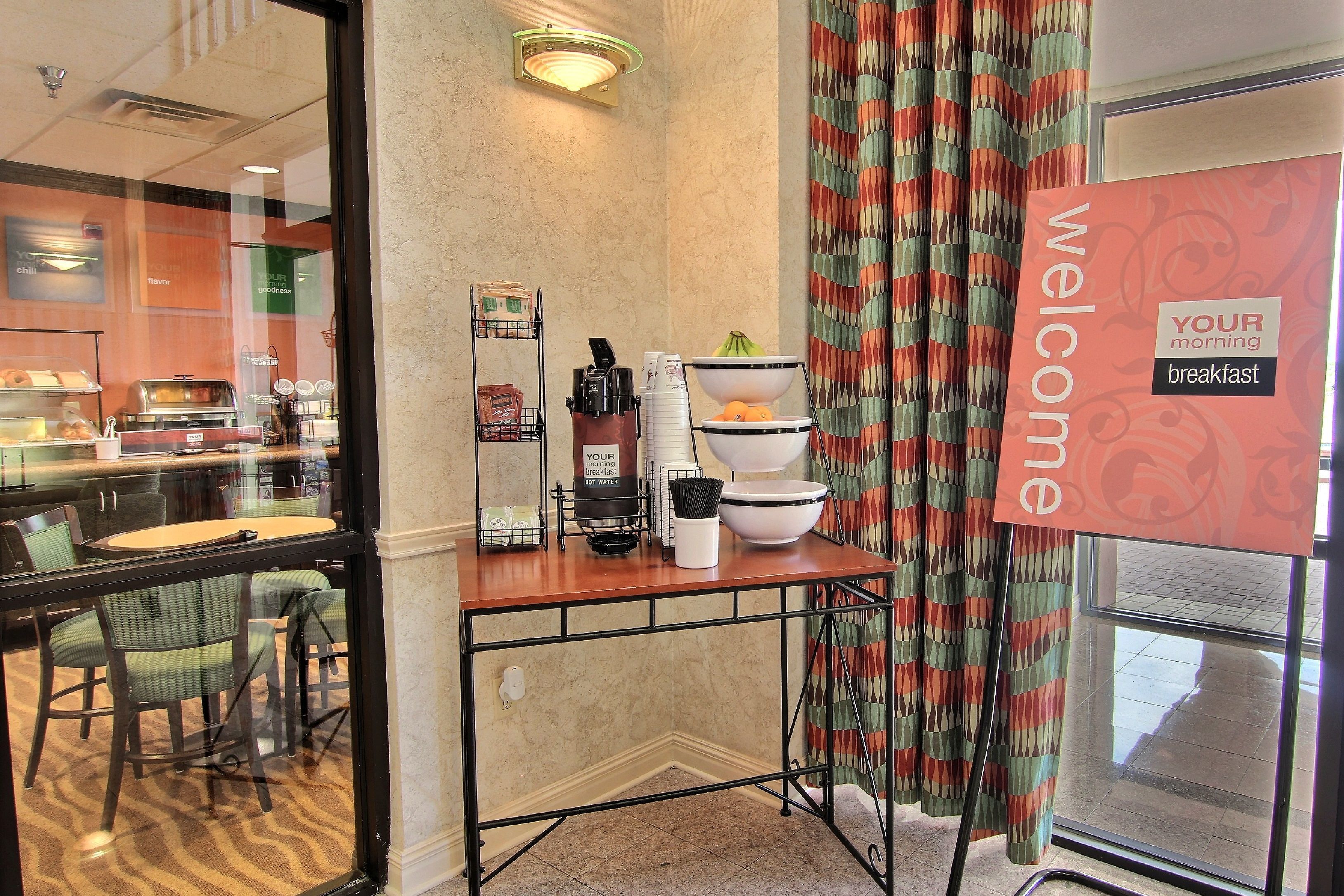 A breakfast area with a counter, chairs, and a 'Welcome' sign.