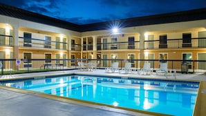 A hotel with a swimming pool, outdoor seating, and multiple balconies. - Quality Inn at Arlington Highlands (Arlington)