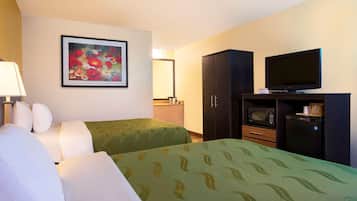 Une chambre d’hôtel avec deux lits, une télévision, un four à micro-ondes et un placard.