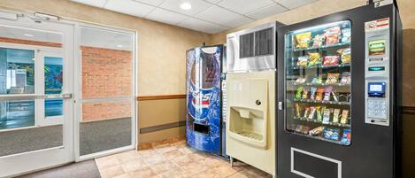 Zona de máquinas expendedoras con un refrigerador de Pepsi y una máquina de aperitivos.