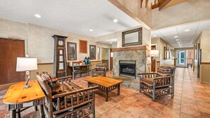 A spacious lobby with a fireplace, wooden furniture, and a stone accent wall. - Quality Inn & Suites Big Stone Gap (Big Stone Gap)