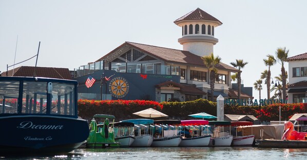 A marina with boats docked, a clock, and a building with a tower.