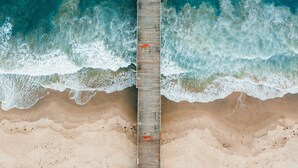 A wooden pier extending into a beach with waves crashing on both sides. - Holiday Inn Express Port Hueneme by IHG (Port Hueneme)
