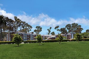 A hotel with multiple-story buildings, a well-maintained lawn, and a clear blue sky. - Holiday Inn Express Port Hueneme by IHG (Port Hueneme)