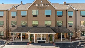 Ein Country Inn & Suites Gebäude mit überdachter Eingangspartei, zahlreichen Fenstern und blauem Himmel.