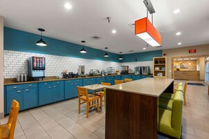 A modern kitchen with blue cabinets, a central island, and pendant lighting.
