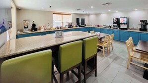 Une cuisine moderne dotée d’un îlot central, de tabourets de bar et d’une table à manger avec des chaises.