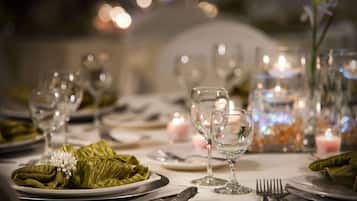 A table set for a formal dinner with clear glassware, plates, and silverware.