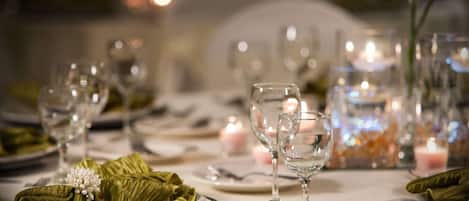 Una mesa dispuesta para una cena formal, con copas, platos y cubiertos de plata.