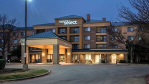 A Sonesta Select hotel with a covered entrance, multiple floors, and a parking lot.