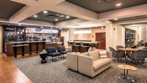 A modern hotel lobby with a bar, seating area, and a dining space. - Sonesta Select Dallas Richardson (Richardson)