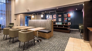 A modern hotel lobby with seating, tables, and artwork on the walls.