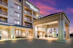 A hotel with a modern design, featuring a prominent entrance canopy and multiple balconies. - Sonesta Select Detroit Novi (Novi)