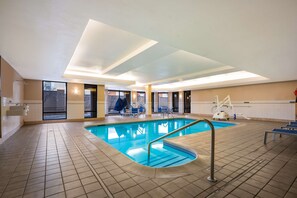 Relax by the serene indoor pool, surrounded by a spacious tiled area.