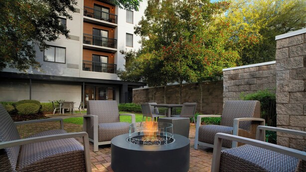 Un patio con mobiliario exterior, una chimenea y un muro de piedra.