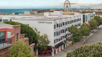 A Courtyard by Marriott hotel with a modern design, located near a Ferris wheel and waterfront views.