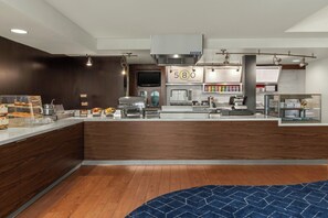 A modern kitchen with a counter, a microwave, a grill, and a digital menu board. - Courtyard by Marriott San Francisco Fisherman's Wharf (San Francisco)