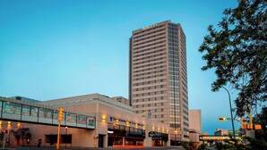 A modern hotel with a prominent 'DELTA' sign, a covered walkway, and a glass facade. - Delta Hotels by Marriott Regina (Regina)