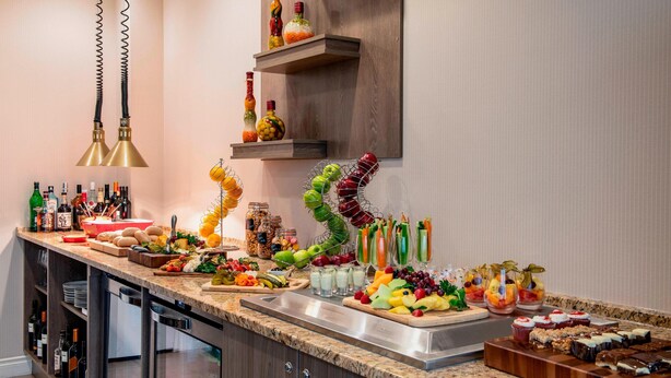A kitchen with a marble countertop, various food items, and a wine rack. - Delta Hotels by Marriott Regina (Regina)