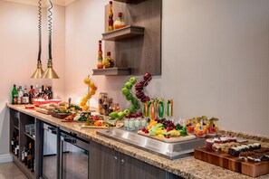 A kitchen with a marble countertop, various food items, and a wine rack.