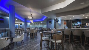 A modern bar area with seating, a bar counter, and a view of the cityscape. - Delta Hotels by Marriott Regina (Regina)