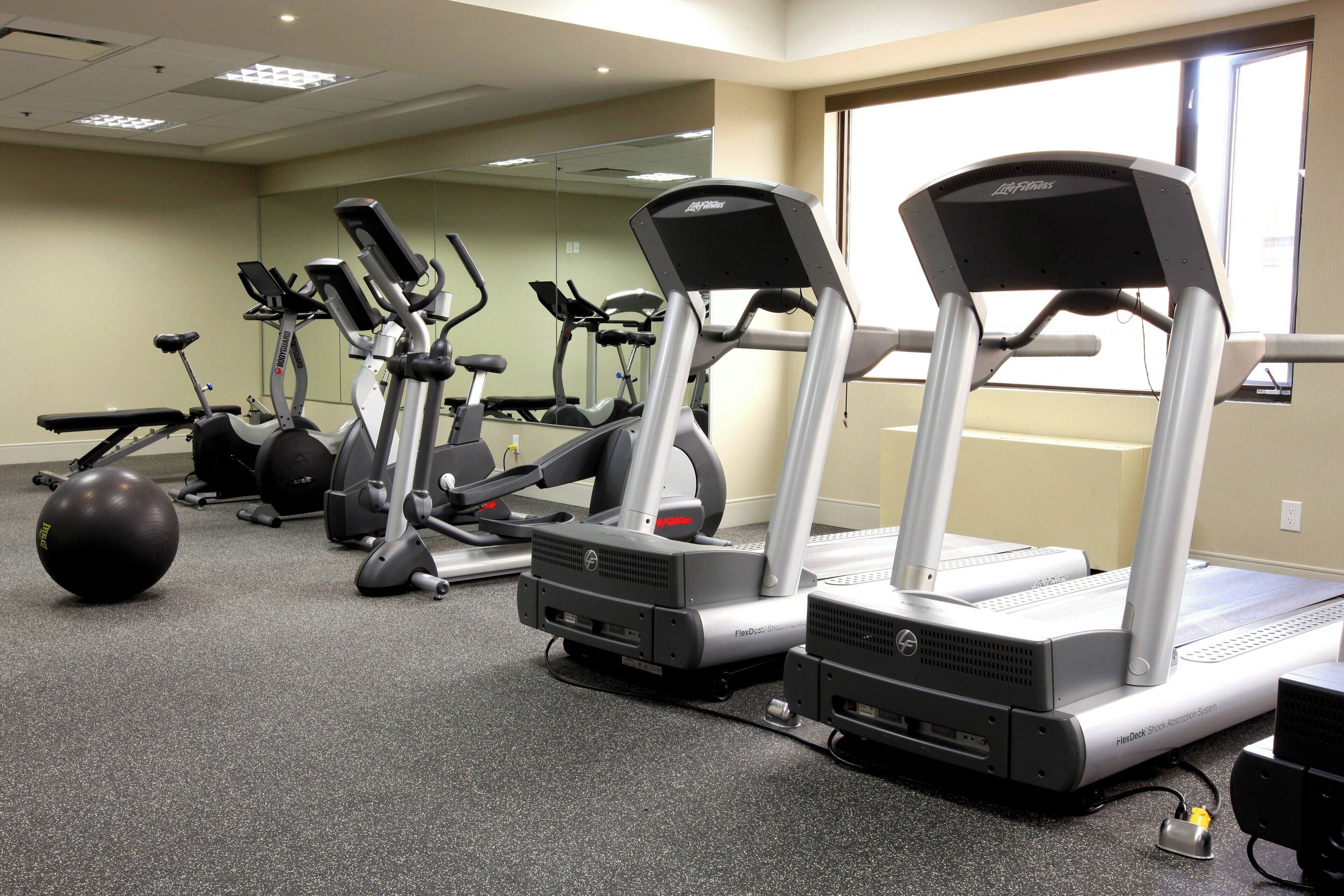 A gym with treadmills, elliptical machines, and a stationary bike.