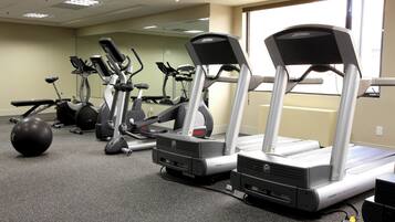 A gym with treadmills, elliptical machines, and a stationary bike.