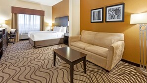 Une chambre d’hôtel avec un lit, un canapé, un bureau et une chaise.