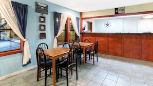 A restaurant with a bar area, wooden tables and chairs, and a Texas sign on the wall. - Days Inn by Wyndham Snyder (Snyder)