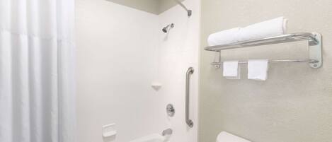 Une salle de bain avec une douche, des toilettes et un porte-serviettes.