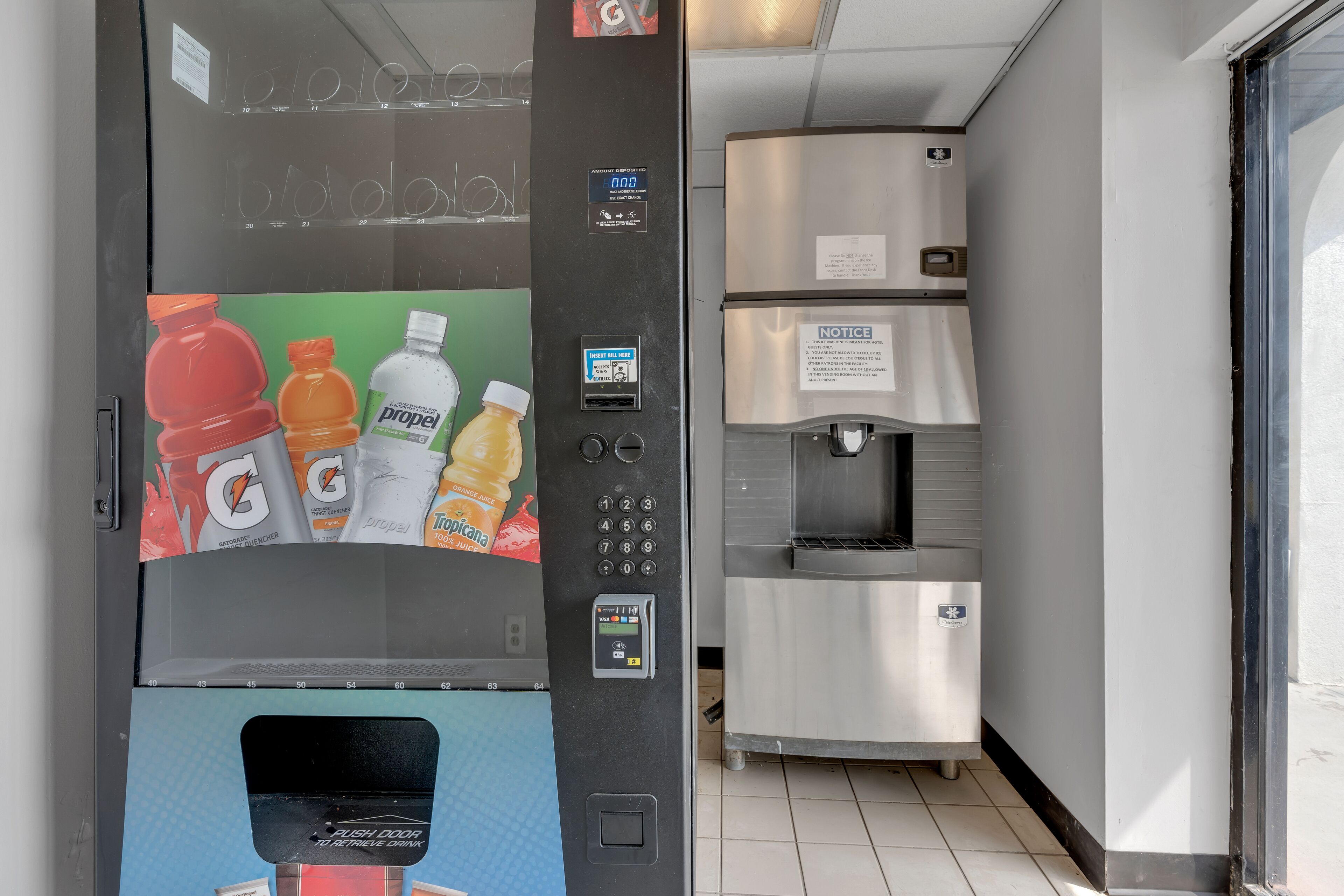 A vending machine with a digital display and a push door for retrieving drinks.