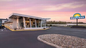 A Days Inn hotel with a modern design, featuring a large glass facade and a parking lot. - Days Inn by Wyndham Wrightstown McGuire AFB/Bordentown (Wrightstown)