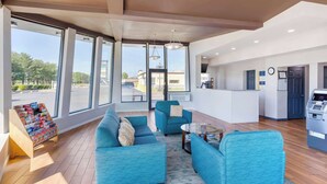 A modern living room with large windows, a sofa set, a coffee table, and a small wooden display unit. - Days Inn by Wyndham Wrightstown McGuire AFB/Bordentown (Wrightstown)