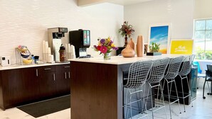 Eine moderne Küche mit einer Kaffeestation, Barhocker und einer großen Kochinsel.