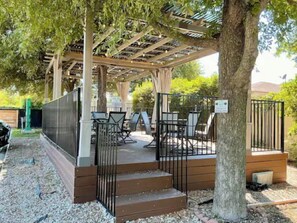 Relax in a serene outdoor space with a pergola, tables, and comfortable seating.