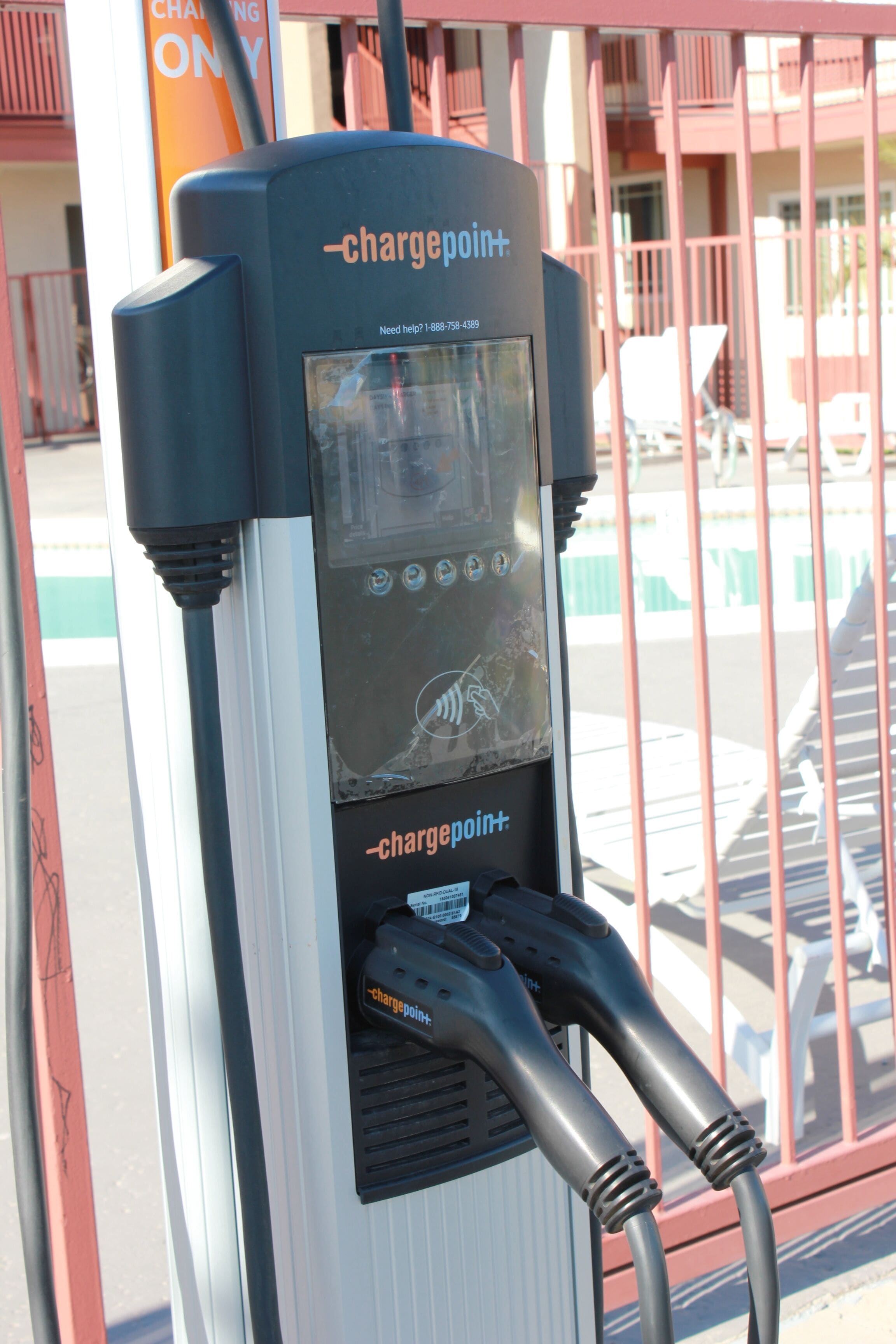 Una estación de carga para vehículos eléctricos ChargePoint+ con dos cables de carga conectados.