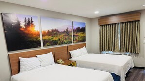 A hotel room with two beds, a wooden headboard, a wall-mounted telephone, and a window with curtains. - Days Inn by Wyndham Barstow (Barstow)
