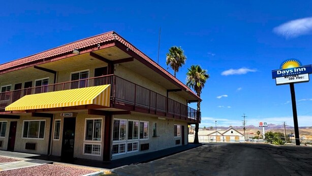 A Days Inn with a red roof, yellow awning, and a sign indicating it is an HBO pool. - Days Inn by Wyndham Barstow (Barstow)