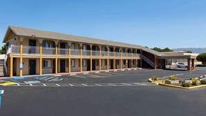 A motel with a long row of rooms, a covered parking area, and a clear blue sky. - Days Inn by Wyndham Ukiah (Ukiah)